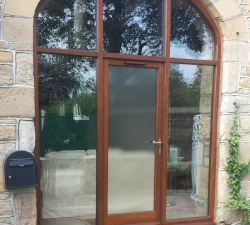 An arched barn door built in 60mm thick Iroko Hardwood and finished with Sikkens.