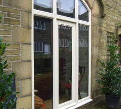 An arched barn door and frame in hand-painted softwood