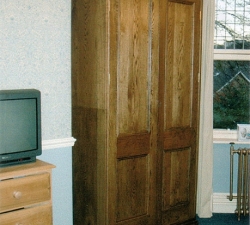 A large, classical style, free-standing Solid Oak wardrobe.  This is one of a pair, built to fit into the alcoves of the bedroom.  