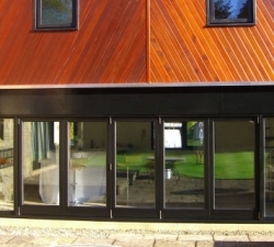 Hardwood folding doors built using the P C Henderson sliding door system - the world leading gear system for folding doors. The doors are 60mm thick Iroko hardwood.