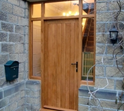 A panelled solid Oak door & frame with double glazed units to the top & sides