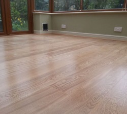 Engineered Prime American White Oak, pre finished with lacquer.  Laid as a floating floor, finished with beading