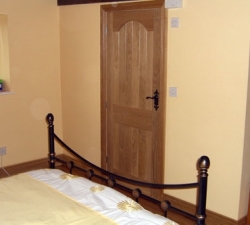 Solid Oak panelled bedroom door with Oak architrave to match. The door has arched detailing to the top of the panelling