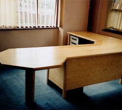 A free-standing solid Ash office desk incorporating a hexagonal meeting table.