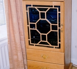 Solid Oak bespoke AV Cabinet with a fretwork glass door.