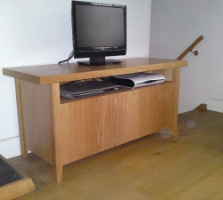 A custom made free-standing media cabinet, incorporating  storage with push doors & tapered legs.